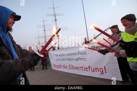 Mit Fackeln Und Transparenten Demonstrieren Entstehungsprozess bin Samstag (29.01.2011) eine Höhle St. Pauli Landungsbrücken bin Hamburger Hafen Gegen Die Elbvertiefung Und Für Den Schutz der Flüsse. Unter Dem Motto "Flüsse Schützen – Leben Schützen" Haben der Bund Für Umwelt Und Naturschutz Deutschland e.V. (BUND) Und der Naturschutzbund Deutschland e.V. (NABU) in Einer Bundesweiten Aktion Mehr Stockfoto