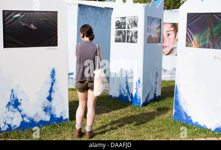 Eine Frau schaut eine Fotoausstellung in der Greenpeace-Dorf am Glastonbury Festival 2013 Stockfoto