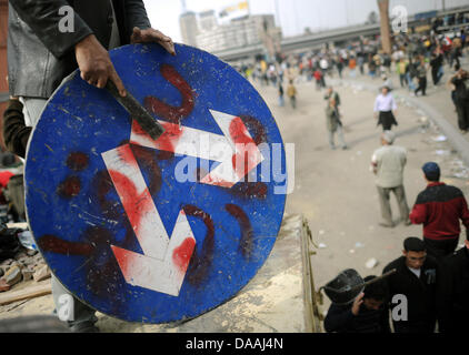 Ein Demonstrant Schlagzeug auf ein Verkehrsschild Tahrir-Platz in Kairo, in der Nähe von 3. Februar 2011. Bereits mehr als 800 Menschen wurden verletzt und mehrere sind bei Zusammenstößen zwischen Anti-Regierungs-Demonstranten und Anhängern von Präsident Mubarak noch wirkenden getötet worden. Foto: HANNIBAL HANSCHKE Stockfoto