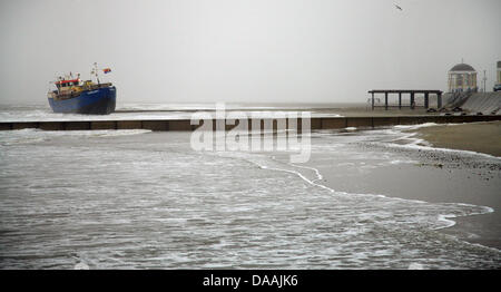 Das Motorschiff Nordland 1 befindet sich vorne an der Strandpromenade von der Nordsee-Insel Borkum, Deutschland, 4. Februar 2011. Das Schiff hatte Material für die neue Promenade an Bord und wurde an Land gespült durch starke Winde und Wellen während der Brandbekämpfung. Es ist zu hoffen, dass das Schiff freigegeben werden durch die Flut, aber wenn nicht das Schiff müssen wieder in tieferes Wasser gezogen werden. Foto: Stockfoto