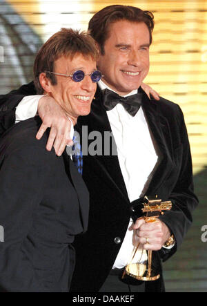 US-Schauspieler John Travolta (R) erhält die Auszeichnung als bester internationaler Schauspieler aus britischer Musiker Robin Gibb während der 46. Goldene Kamera Award Zeremonie in Berlin, Deutschland, 5. Februar 2011. Die Auszeichnung würdigt die Publikumslieblinge aus Film, Fernsehen, Sport und Medien. Foto: Tobias Schwarz Dpa/lbn Stockfoto