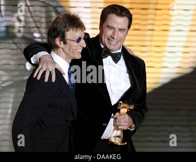 US-Schauspieler John Travolta (R) erhält die Auszeichnung als bester internationaler Schauspieler aus britischer Musiker Robin Gibb während der 46. Goldene Kamera Award Zeremonie in Berlin, Deutschland, 5. Februar 2011. Die Auszeichnung würdigt die Publikumslieblinge aus Film, Fernsehen, Sport und Medien. Foto: Tobias Schwarz Dpa/lbn Stockfoto