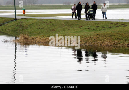 Die Menschen gehen auf eine Elbe-Deich in Doemitz, Deutschland, 23. Januar 2011. Die Elbe-Flut erreicht ihren Höhepunkt an diesem Wochenende in Mecklenburg Vorpommern. Der Wasserstand der Elbe in Doemitz war in der Nacht von 22 bis 23 Januar 6,72 m. D. h. 8 cm mehr als der Rekord des Jahres 2006 war die auf 6,64 Meter. Foto: Jens Büttner Stockfoto