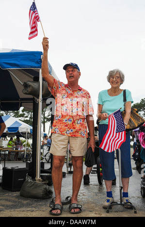 Verzichten Sie pensionierter Oberstleutnant der Air Force Paul Ozyck (links) und Mary Amyel, amerikanische Flaggen während der Karton Boot-Regatta am 18. Stockfoto