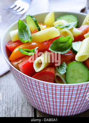 Pasta-Salat mit Gurken, Tomaten und Basilikum Stockfoto