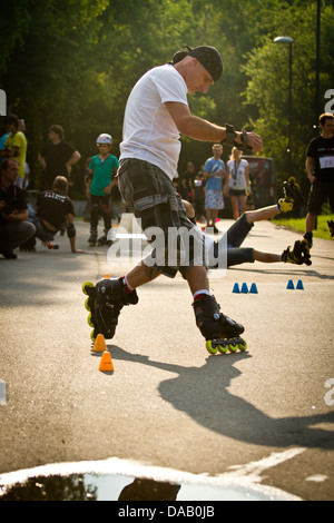 Mann-Inline-Skating durch Slalom Kegel Stockfoto