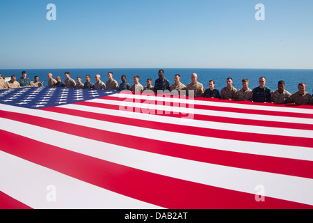 Matrosen und Marinesoldaten Anzeigen der nationalen Flagge zu Ehren des Independence Day auf amphibischer Angriff Schiff USS Kearsarge ( Stockfoto