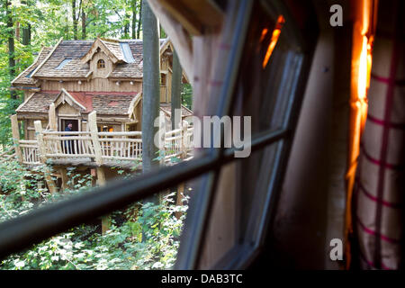 Ein Besucher steht auf einem Balkon ein Baumhaus in Cleebronn, Deutschland, 26. September 2011. Der Erlebnispark "Tripsdrill" soll fünf Baumhäuser rustikale Gastgeber in der Nähe von seinen Wildpark bieten. Die Baumhäuser bieten Platz für bis zu sechs Personen mit den gewohnten Komfort der Hotelzimmer. Foto: TOBIAS KLEINSCHMIDT Stockfoto