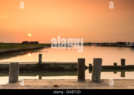 Die Sonne geht über dem kleinen Hafen am Blackshore, Walberswick in Suffolk. Stockfoto