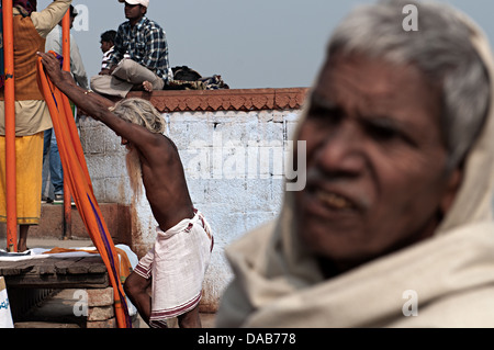 Sadhu üben Yoga-Übungen auf den Ghats. Varanasi, Benares, Uttar Pradesh, Indien Stockfoto