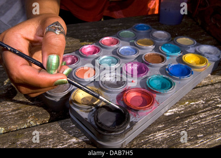 Gesicht Maler Hand, Pinsel und Palette, Alton, Hampshire, UK. Stockfoto