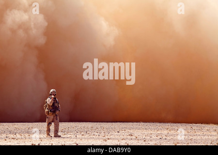 Ein US-Marine verlor in einer Wolke aus Staub Signale georgische Soldaten zugewiesen der 33. Licht-Infanterie-Bataillon an der Entnahmestelle Hubschrauber während der Operation Northern Lion II 3. Juli 2013 in der Provinz Helmand, Afghanistan. Stockfoto