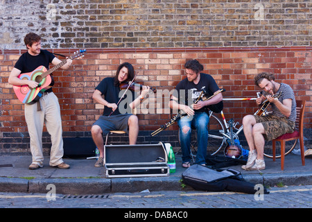 Eine Bande von jungen Straßenmusiker führen auf den Straßen von London an der Columbia Road Flower Markt, London, England, GB, UK. Stockfoto