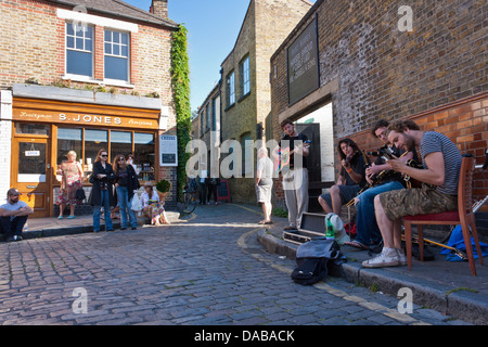 Eine Bande von jungen Straßenmusiker führen auf den Straßen von London an der Columbia Road Flower Markt, London, England, GB, UK. Stockfoto