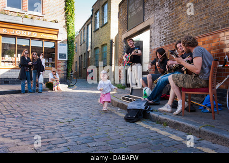 Eine Bande von jungen Straßenmusiker führen auf den Straßen von London an der Columbia Road Flower Markt, London, England, GB, UK. Stockfoto