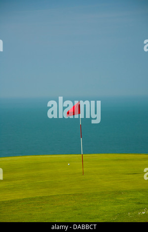 Golfflagge in hellem Grün Grün mit Blau des Meeres im Hintergrund. Stockfoto