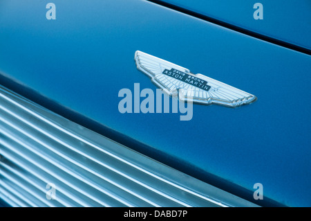 Aston Martin-Abzeichen auf blau irisierender DB6 Sportwagen Motorhaube zeigt Chrom-Kühlergrill Stockfoto