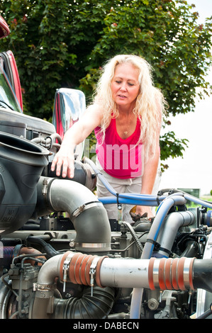 Erwachsene Frau LKW-Fahrer eine Pre-Trip-Inspektion auf ihrem Lkw vor ihrem Lauf zu tun. Stockfoto