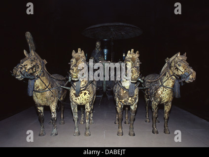 Der Qin-dynastie bronze Modell chariot durch vier Bronzene Pferde gezogen, mit einem einzigen stehenden Fahrer und eine Bronze Regenschirm auf einem Ständer platziert neben ihm im Museum der Terracotta Krieger und Pferde von Qin Shi Huang in Lintong Bezirk in Xi'an, die Hauptstadt der Provinz Shaanxi, China gespeichert Stockfoto