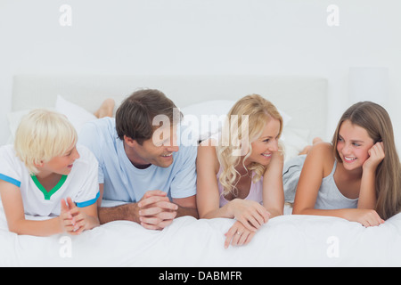 Familie auf dem Bett liegend Stockfoto