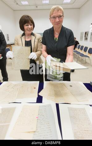 Kornelia Küchmeister, Leiter der Handschriftenabteilung der Staatsbibliothek Schleswig-Holstein und Anke Spoorendonk (SSW), Kultusminister des Landes Schleswig-Holstein (L-R), posieren mit Hebbel Manuskripte gefährdet durch Säure und die restaurierten Handschriften des Romans "Der Reiter auf dem weißen Pferd" von Theodor Storm in Kiel, Deutschland, 10. Juli 2013. Foto: MARKUS SCHOLZ Stockfoto