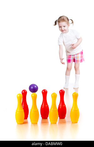 Kind Mädchen wirft Ball Spielzeug bowling-Pins abzureißen. Kegeln im Mittelpunkt. Stockfoto