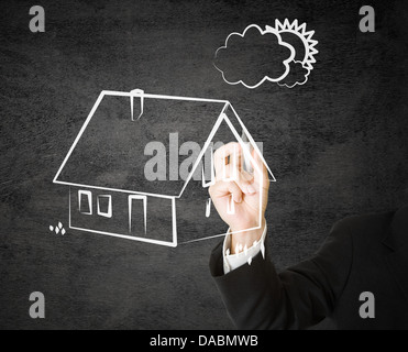 Geschäftsmann, die Skizze eines Hauses auf schwarzem Hintergrund Stockfoto