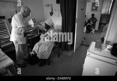 Dr. Jonathan Victor Larsen MBchB (UCT) F.R.C.O.G neigt dazu, Patienten im Büro in Eshowe Krankenhaus während der letzten Woche Service als eine Stockfoto