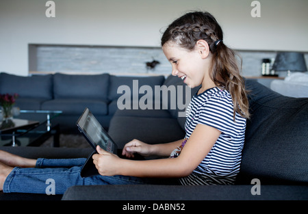 Junges Mädchen schaut im Internet auf ihrem iPad in der Lounge - Stonehurst Estate, Kapstadt, Südafrika. Stockfoto