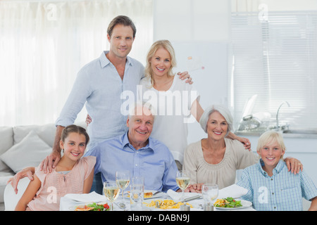 Großfamilie lächelnd am Esstisch Stockfoto