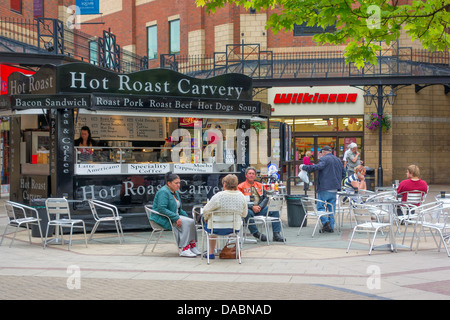 Menschen sitzen und entspannen am Essen und trinken Stand in James Cook Square Middlesbrough an einem heißen Sommertag Stockfoto