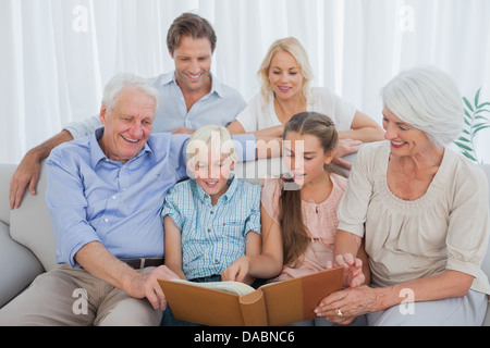 Großfamilie mit Blick auf ein Foto album Stockfoto