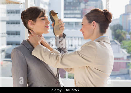 Geschäftsfrau erwürgt, eine andere, die mit ihrem Schuh Verteidigung Stockfoto