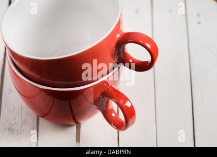 Zwei rote Kaffeetassen auf hölzernen Hintergrund Stockfoto