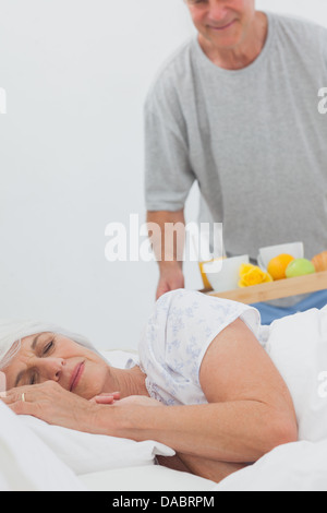 Mann bringen schlafende Frau Frühstück im Bett Stockfoto