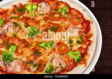 Pizza mit Shrimps und Broccoli am Tisch Stockfoto