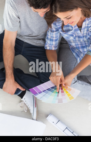 Frau zeigt auf Farbtafeln sitzen in ihrem neuen Haus Stockfoto