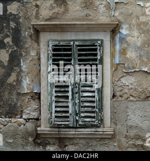 Shuttered Fenster mit verwitterten grünen Fensterläden und abblätternde Farbe auf ein Haus in Dubrovnik, Kroatien Stockfoto