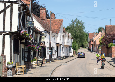 Zwei Radfahrer, Radfahren auf der Straße in Kersey, gilt als die schönste und malerischste Dorf in Suffolk, England. Stockfoto