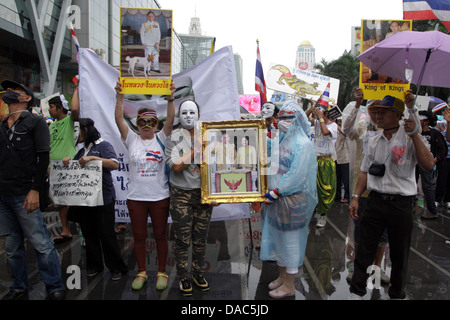 Guy Fawkes weiße Masken Demonstranten halten Porträt von Thailands König Bhumibol Adulyadej und Königin Sirikit bei protest Stockfoto