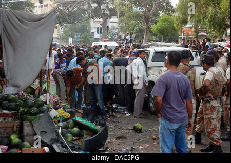 Nach Selbstmord Bombe Angriff auf Pakistans Präsident Asif Ali Zardari Sicherheitschef, Bilal Sheikh anzeigen. Der Sicherheitsbeamte und Bombe Abgang im Kader sind in der Inspektion die Ausmaße der Schäden nach suizidalen Bombenanschlag in der Nähe von Jamia Binoria in Karachi auf Mittwoch, 10. Juli 2013 beschäftigt. Mindestens drei Menschen getötet und elf Verletzte in der mächtigen Explosion die belebte Neustadt-Viertel im Herzen von Karachi, weniger als einen Kilometer von der Quaid Mausoleum erschüttert. Stockfoto
