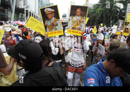 Guy Fawkes weiße Masken Demonstranten halten Porträt von Thailands König Bhumibol Adulyadej und Königin Sirikit bei protest Stockfoto