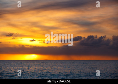 Goldener Sonnenuntergang nach einem Montserrat Vulkanausbruch von Antigua, die Insel Redonda am Horizont gesehen. Stockfoto