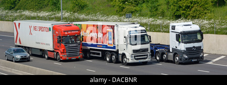 Drei Lastwagen und ein Auto überholen auf einer vierspurigen Abschnitt der Autobahn M25 London Orbital Stockfoto