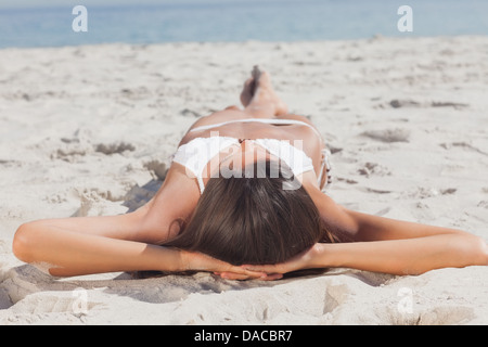 Frau am Strand vor dem Ozean liegen Stockfoto