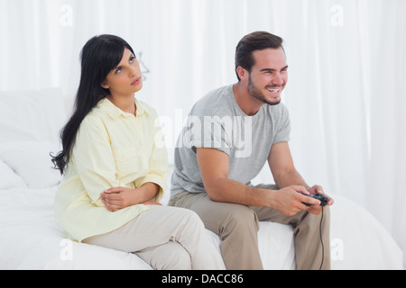 Verärgert Frau blickte, während ihr Freund spielen von Videospielen Stockfoto