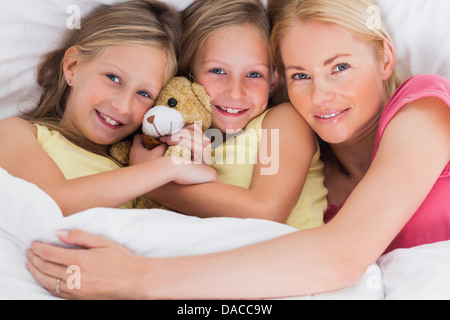 Frau Nickerchen im Bett mit ihren süßen Kindern Stockfoto