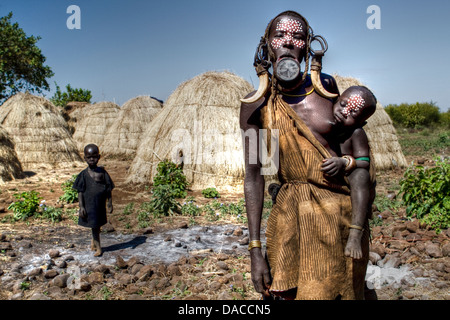 Mursi-Frau mit Clay Disc in Unterlippe und ihr Kind in einem Dorf im Süden Äthiopiens Stockfoto
