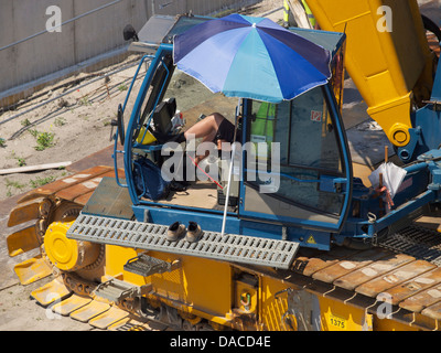 Kran-Treiber auf einer Baustelle mit einer entspannten Haltung gegenüber seiner Arbeit. Breda, Niederlande Stockfoto