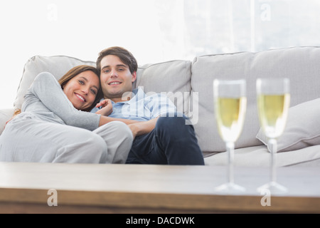 Schönes paar ruht auf einer Couch mit Kanneluren Champagner Stockfoto